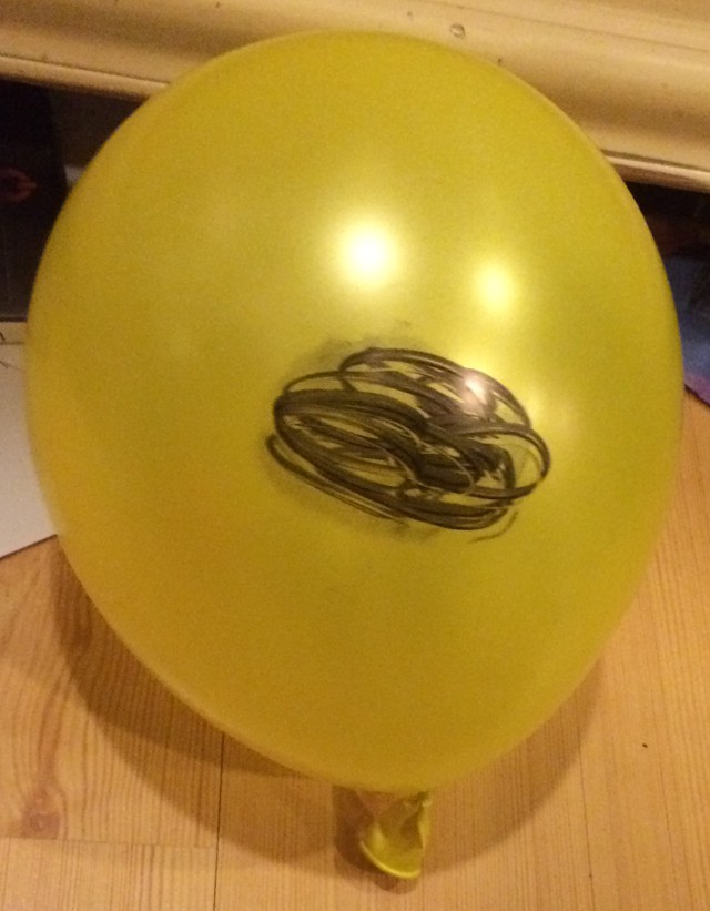 image of a face drawn on a balloon with marker