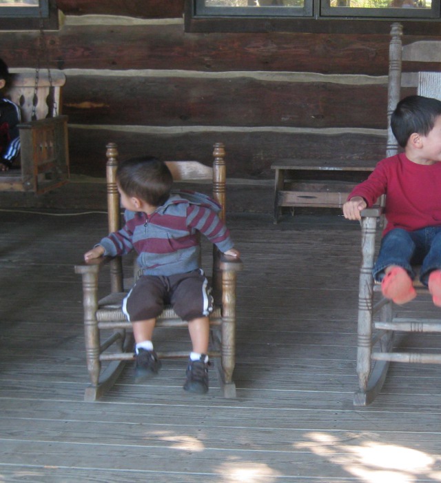 children relaxing in rocking chairs on a front porch