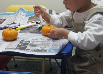 picture of a child coloring a small pumpkin