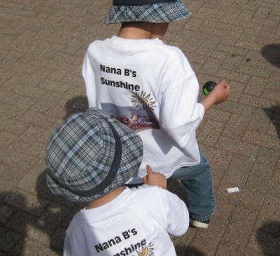 picture of a child looking at a family photo on the back of another kid's shirt