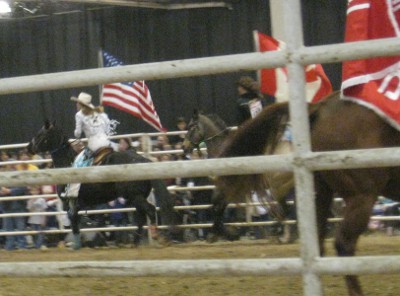 photo of rodeo horses parading the flags around the arena