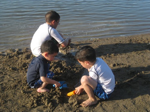 children playing in the sand at the beach