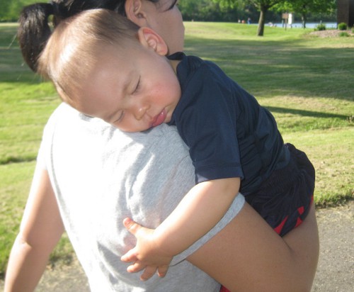 sleeping baby being carried by his mother