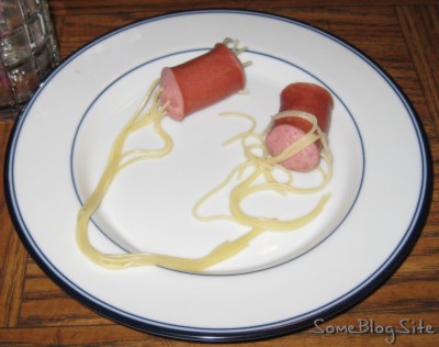 a plate with noodle-filled hot dogs