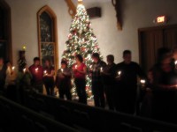 people singing by candlelight in a church