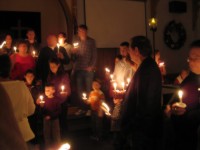 people singing by candlelight in a church