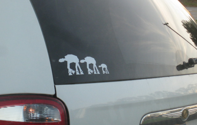 minivan with AT-AT stickers on the back window to represent father, mother, and child in the family