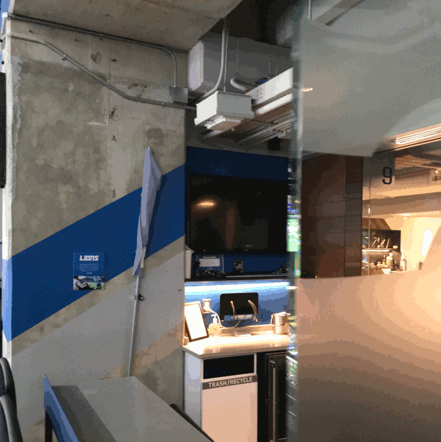 image of the Terrace Suites at Ford Field, showing a TV screen through the glass divider