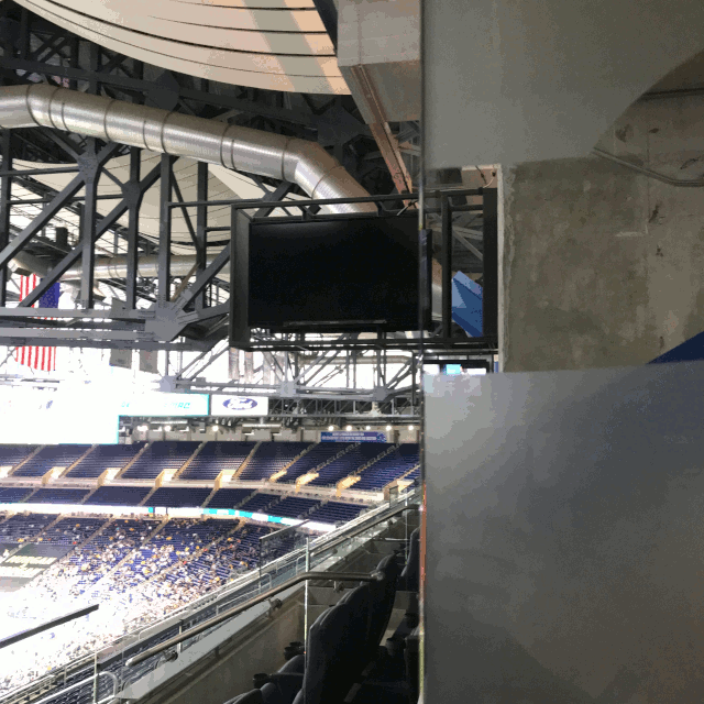 image of the Terrace Suites at Ford Field, showing a TV screen through the glass divider