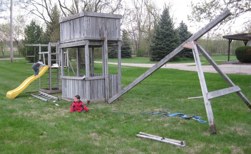 picture of a wooden play structure still needing some assembly