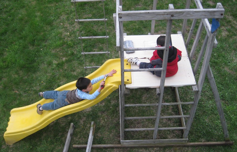 picture of a children helping assemble a wooden play fort