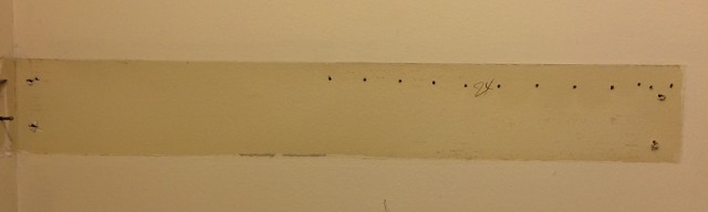 image of holes drilled in a wall to find the stud