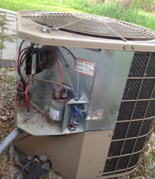 image of the outside unit of a central air conditioning system with the cover off
