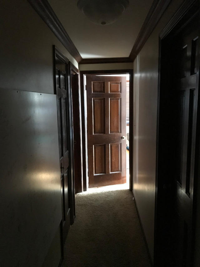 image of a hallway that is dark because doors are mostly closed or slightly open