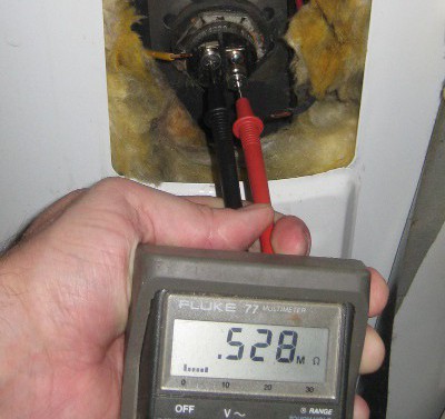 picture of a multimeter measuring resistance of a bad water heater element