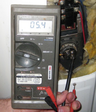 picture of a multimeter measuring resistance of a bad water heater element