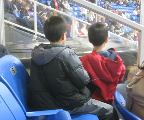 picture of kids watching a Zamboni about to enter the rink