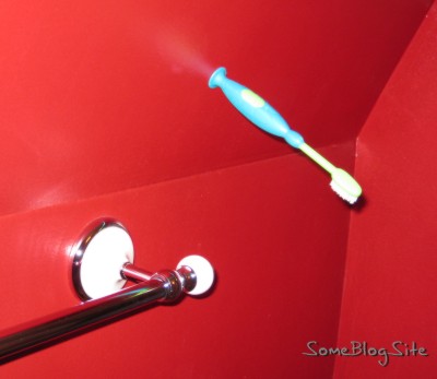 Picture of a toothbrush stuck to a bathroom wall