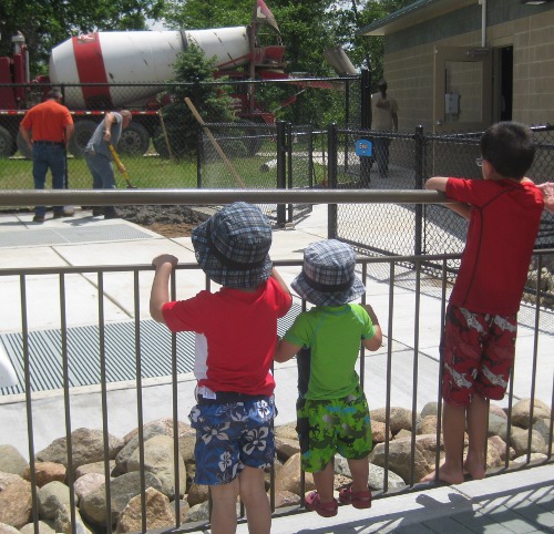 photo of boys watching a cement mixer at work