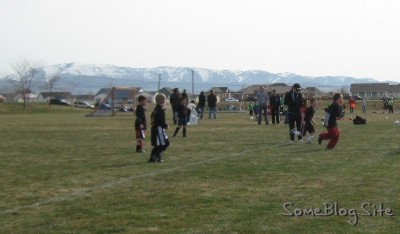 photo of children's soccer game with mountains in the background