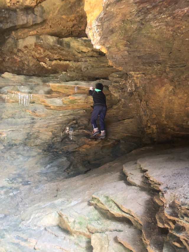 image of a child climbing some rocks at Conkles Hollow hiking area in Hocking Hills Ohio