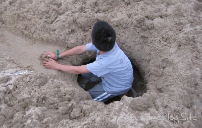 picture of a child digging a hole at the Lake Michigan beach at Maranatha