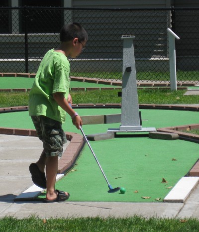 picture of a child playing mini golf