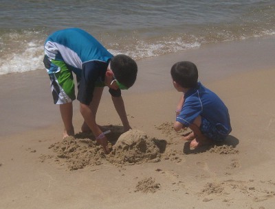 picture of children digging in the sand at the beach