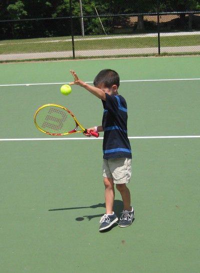 picture of a child serving a tennis ball