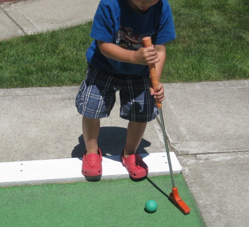picture of a child playing mini golf