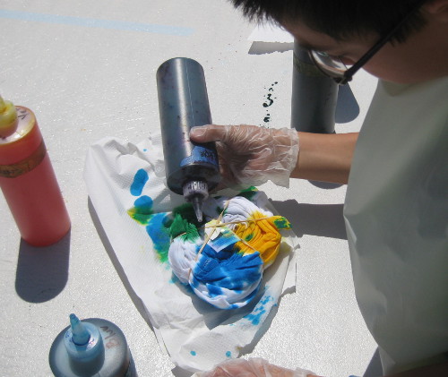 picture of a child making a tie-dye T-shirt at camp