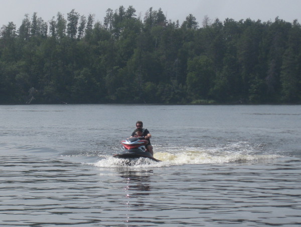 photo of jet-ski heading back on a lake