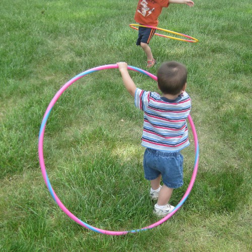 photo of a toddler trying to hula hoop