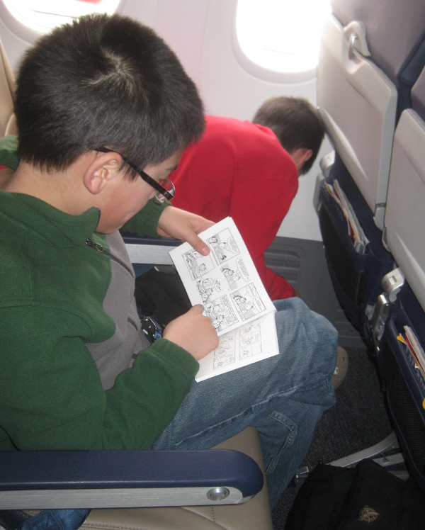 photo of child reading on an airplane