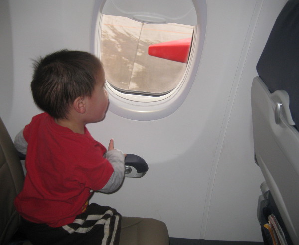 photo of child looking out an airplane window