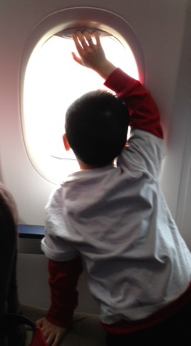 photo of child looking out an airplane window