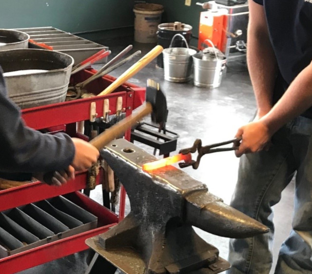 image of a forge and anvil setup, hammering a rail spike to make the blade of the dagger