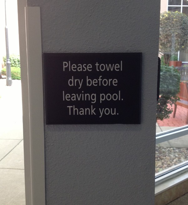 image of a sign at a hotel pool that says to towel dry before leaving pool