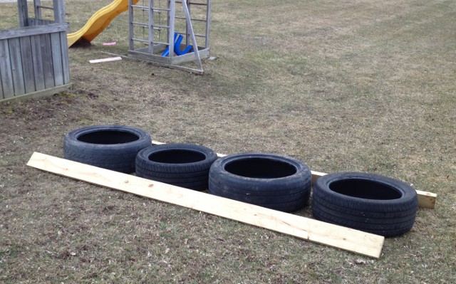 image of old tires along some board to measure as a ladder