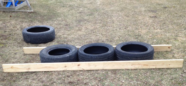 image of old tires along some board to measure as a ladder