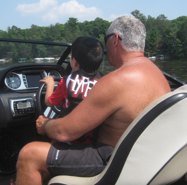 photo of a child driving a boat