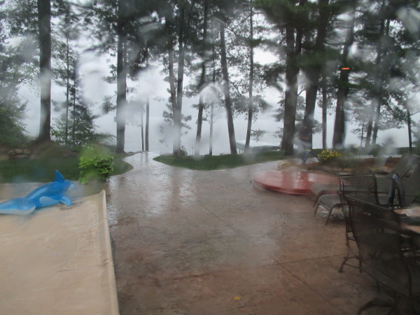 photo of a rain-soaked window look out at a lake