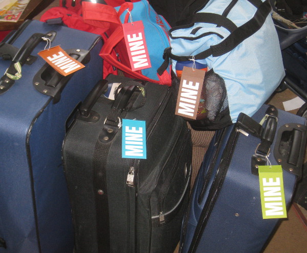 photo of luggage and suitcases with name tags that say 'mine'